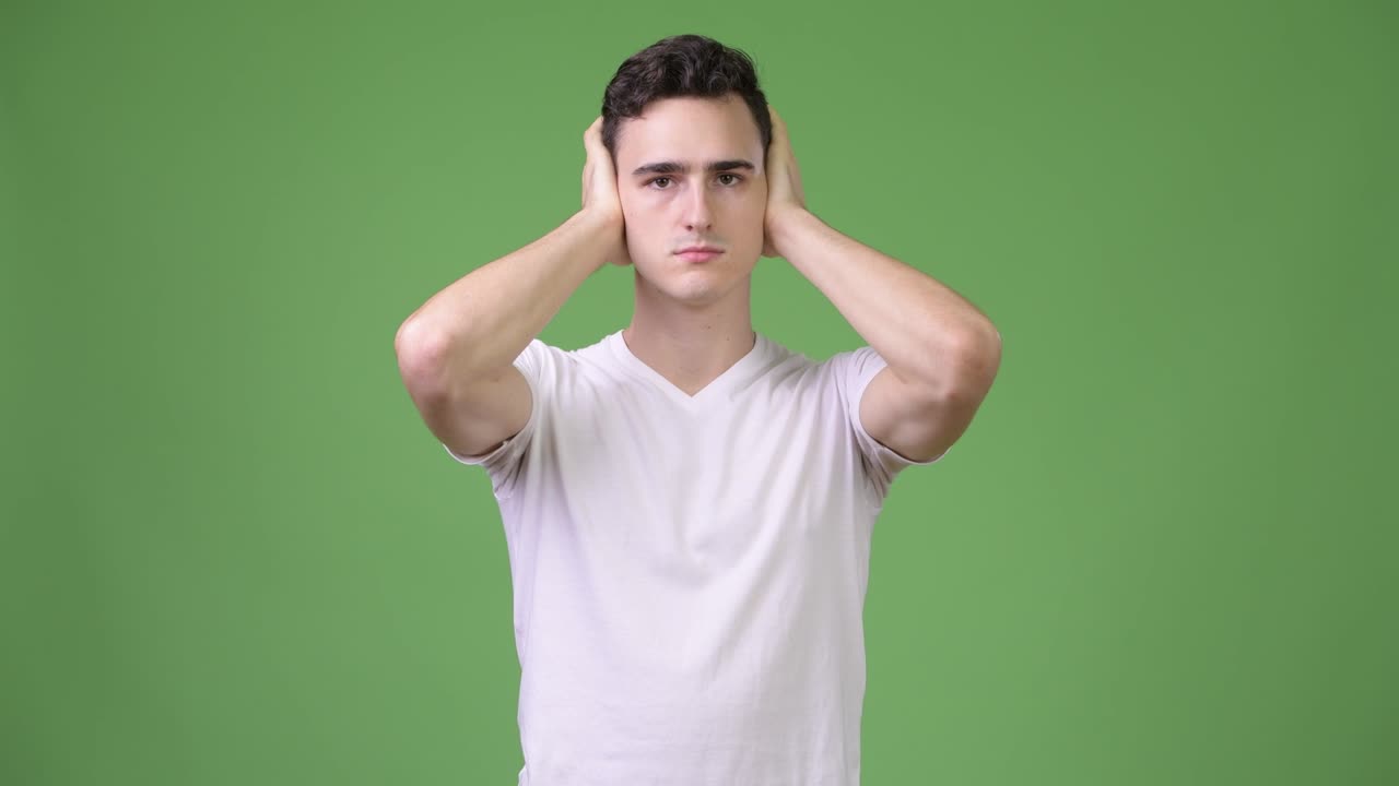 Young handsome man covering ears as three wise monkeys concept