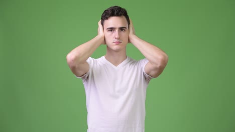 young handsome man covering ears as three wise monkeys concept