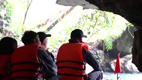 people in life jackets exploring a cave