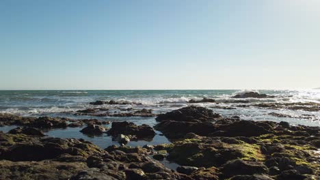 walking along a rocky beach, from right to left