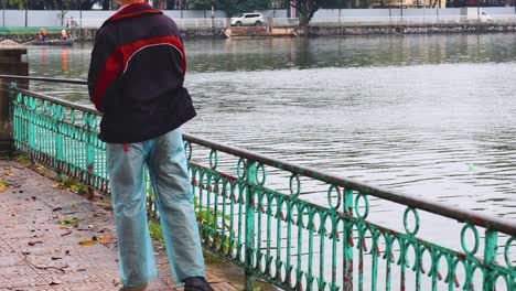 person fishing at a pond in hanoi, vietnam