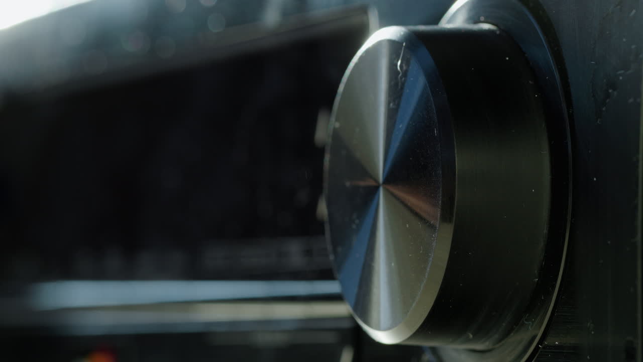 регулирование уровня громкости на приемнике. крупный план пальцев поворачивает ручку