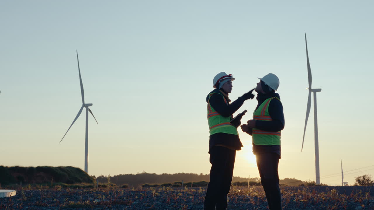 Two Renewable Energy Engineers Working Together at Wind Power Plant