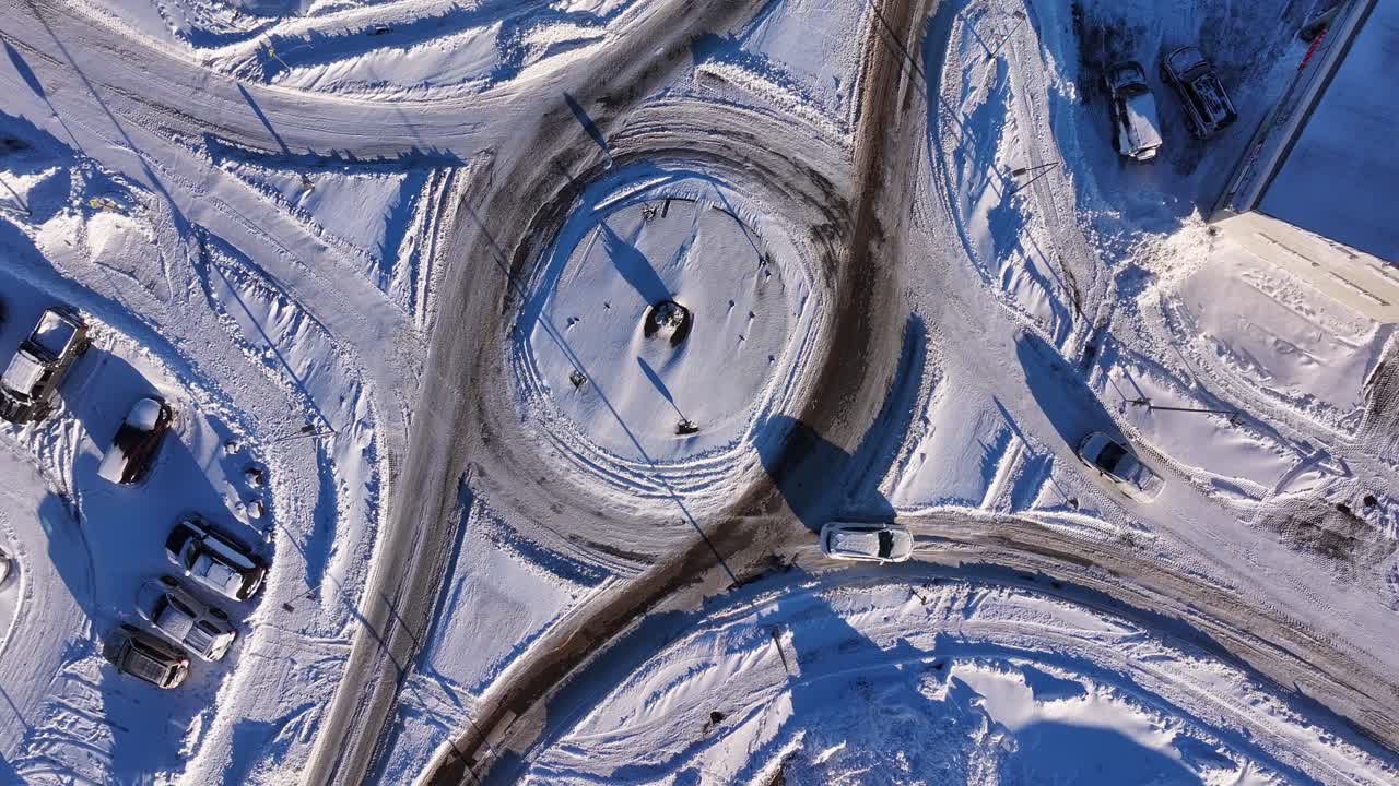 Vista dall'alto di una rotonda stradale coperta di neve durante l'inverno in Islanda. Ripresa aerea rotante dall'alto.