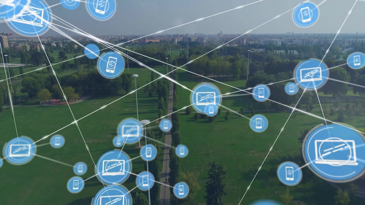 Showing digital network overlaying aerial view of urban park featuring blue laptop and phone icons