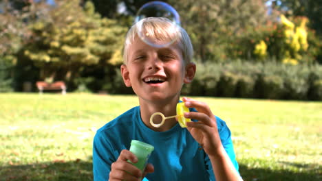 young boy blowing into a bubble wand