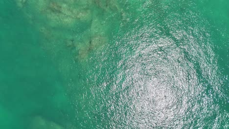 drone footage captures the serene turquoise waters and rocky coastline of phuket, thailand, highlighting the natural beauty and tranquility