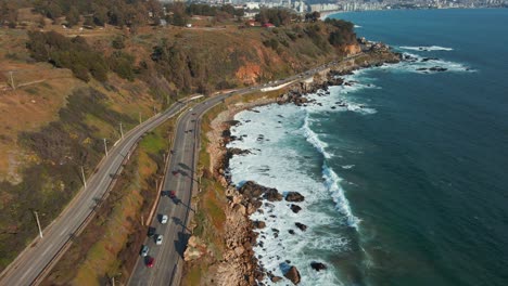 vista aérea siguiendo el tráfico costero de la avenida borgoño inclinándose hacia la costa del paisaje urbano soleado de reñaca