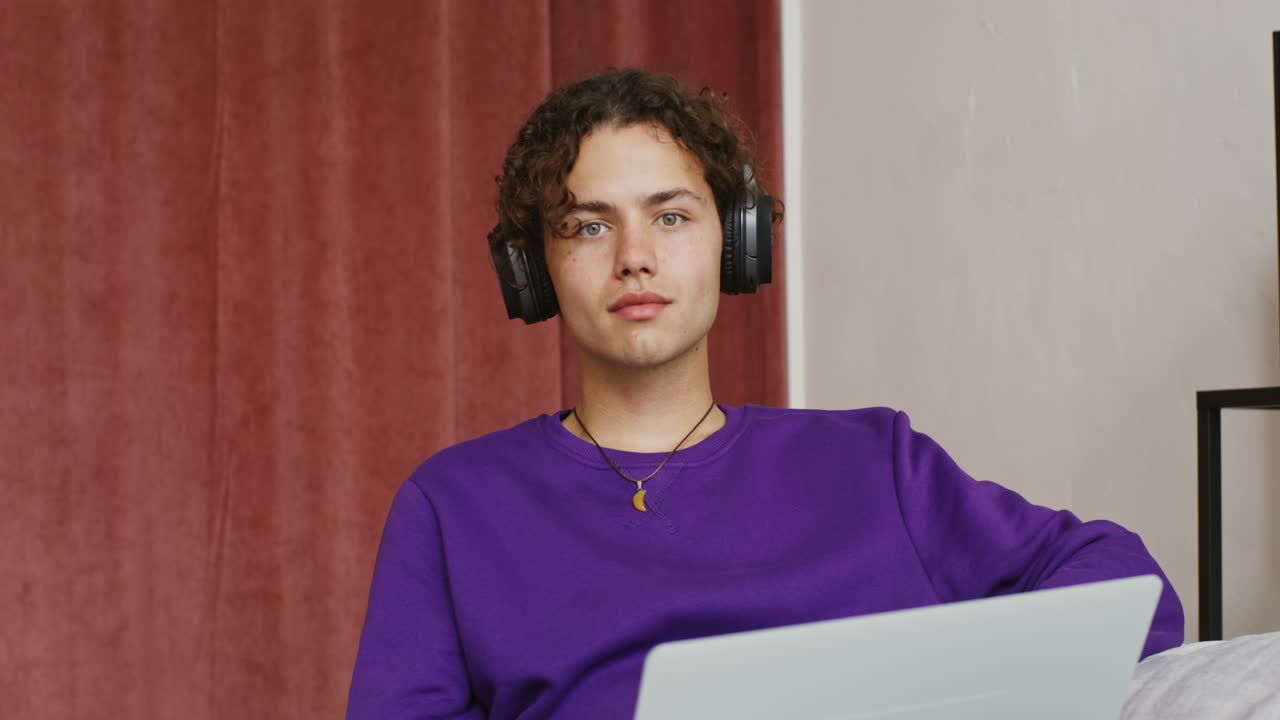 Jovem estudando em casa com fones de ouvido