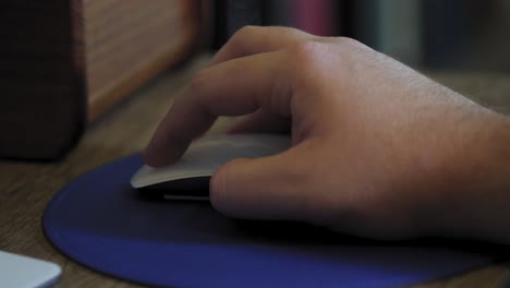 el hombre usa el mouse de la computadora con el mouse pad azul de cerca