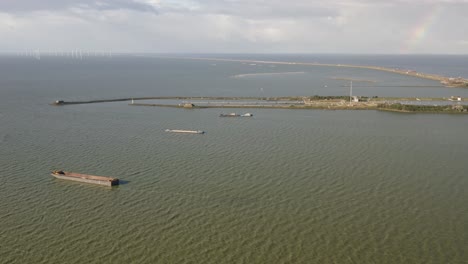 aerial shot of water around the afsluitdijk causeway in kornwerderzand in friesland, the netherlands, on a sunny day