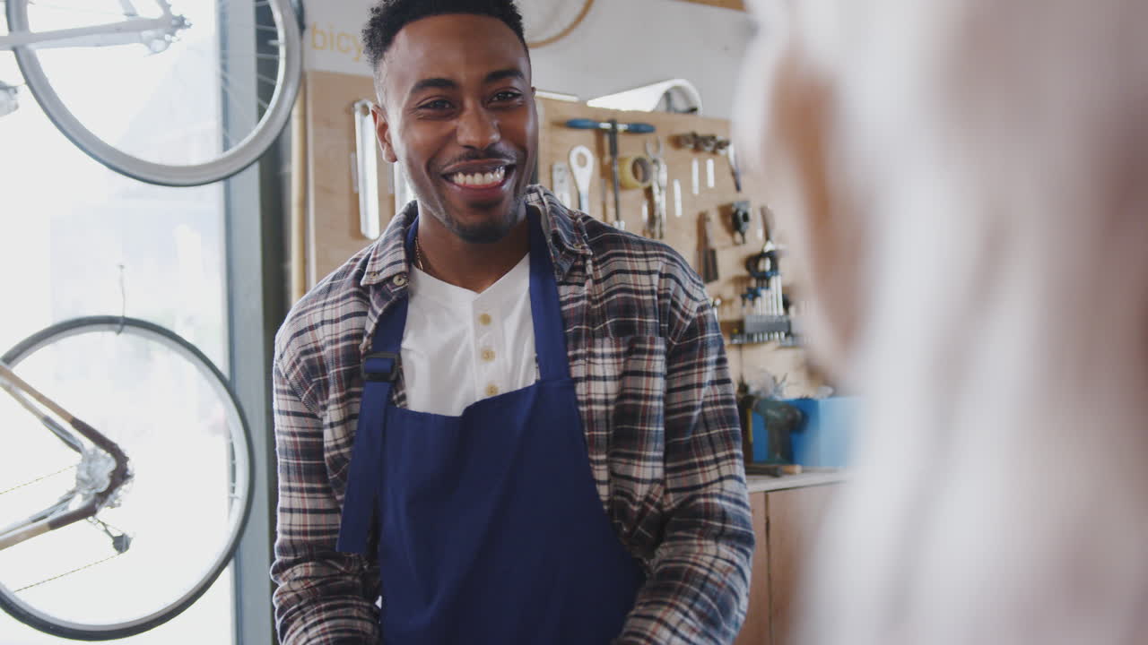 equipo multicultural de aprendices en un taller ensamblando el marco de una bicicleta construida a mano