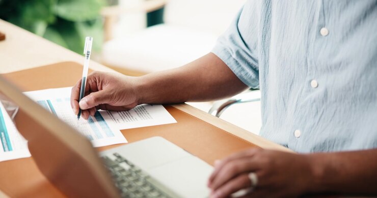 Professional Man Reviewing Financial Documents at Desk
