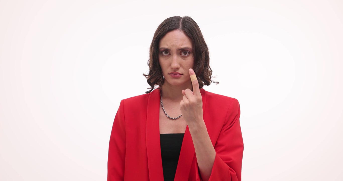 Upset woman raises index finger wiping tears from eyes with hand
