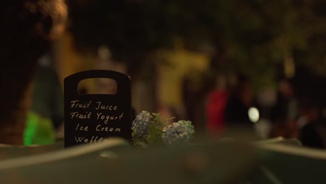 night club menu with fresh juice and ice cream and people walking on city promenade