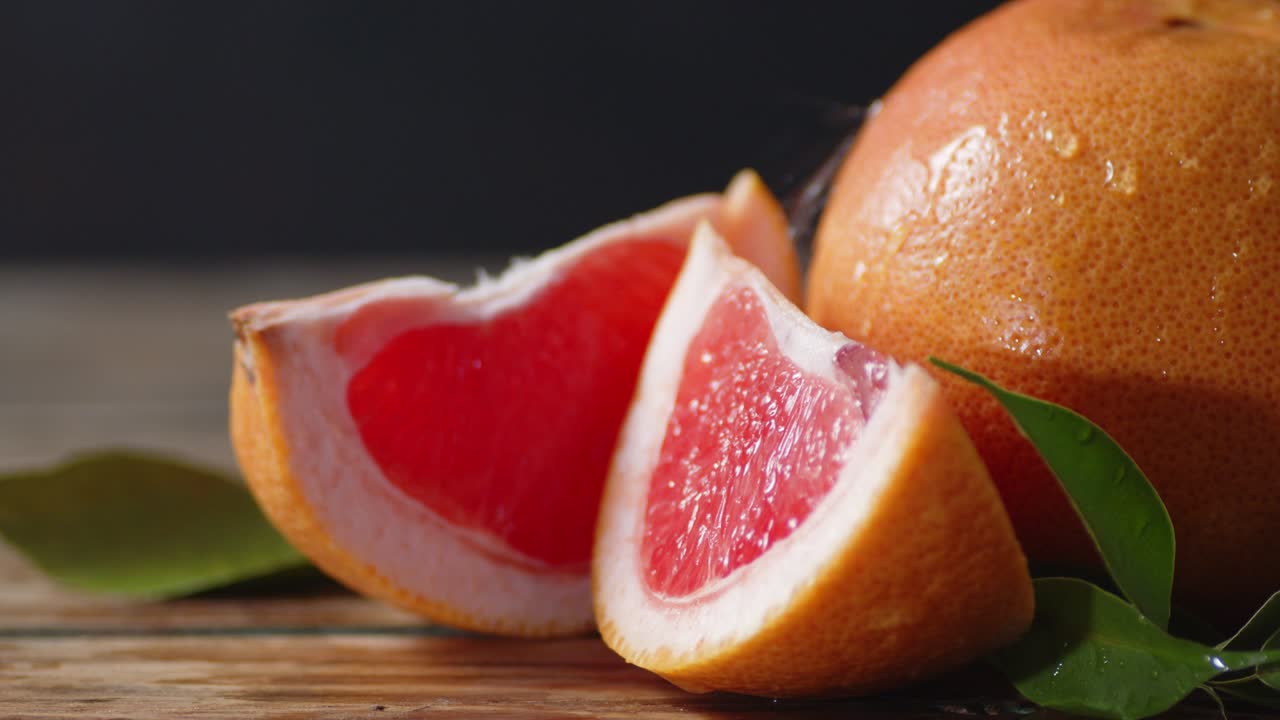 en pomelo jugoso con hojas que caen gotas de agua.