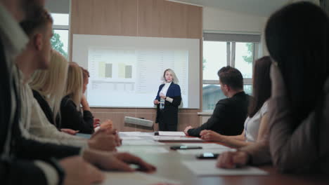 una entrenadora y experta financiera está dando una conferencia para empresarios y empresarios