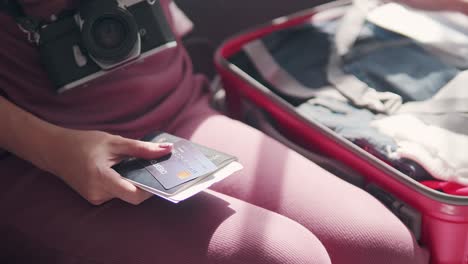 las mujeres están empacando una maleta para viajar con pasaporte y tarjeta de crédito
