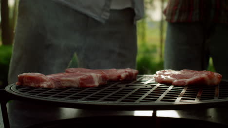 chef poniendo rebanadas de carne en la parrilla afuera