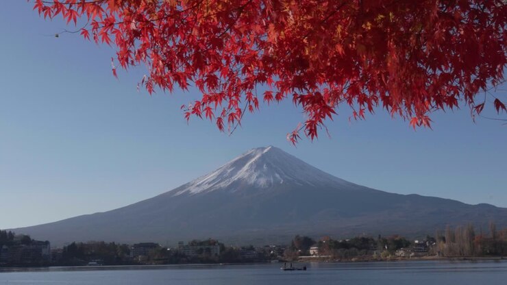 Ampia inquadratura del Lago Kawaguchiko e del Monte Fuji con alberi di acero rosso durante il culmine dell'autunno in Giappone