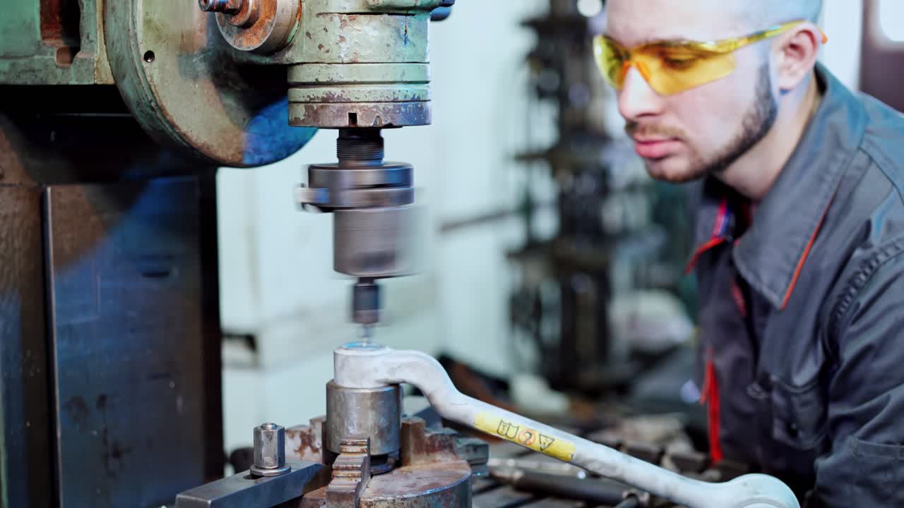 Cutting metal with machine. Worker in factory on the machine