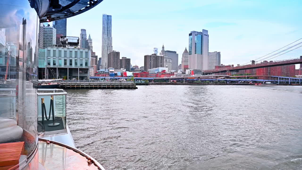 Travelling on board of the modern boat. Watching the skyline of New York and the Brooklyn Bridge at backdrop