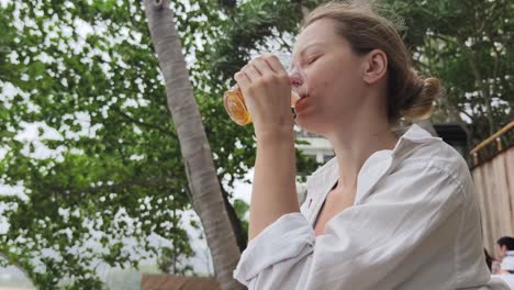 woman enjoying a drink at a tropical beach resort