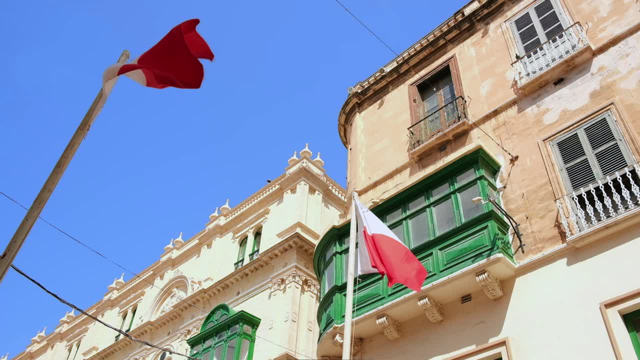 Two flags of Malta waving in the city center.