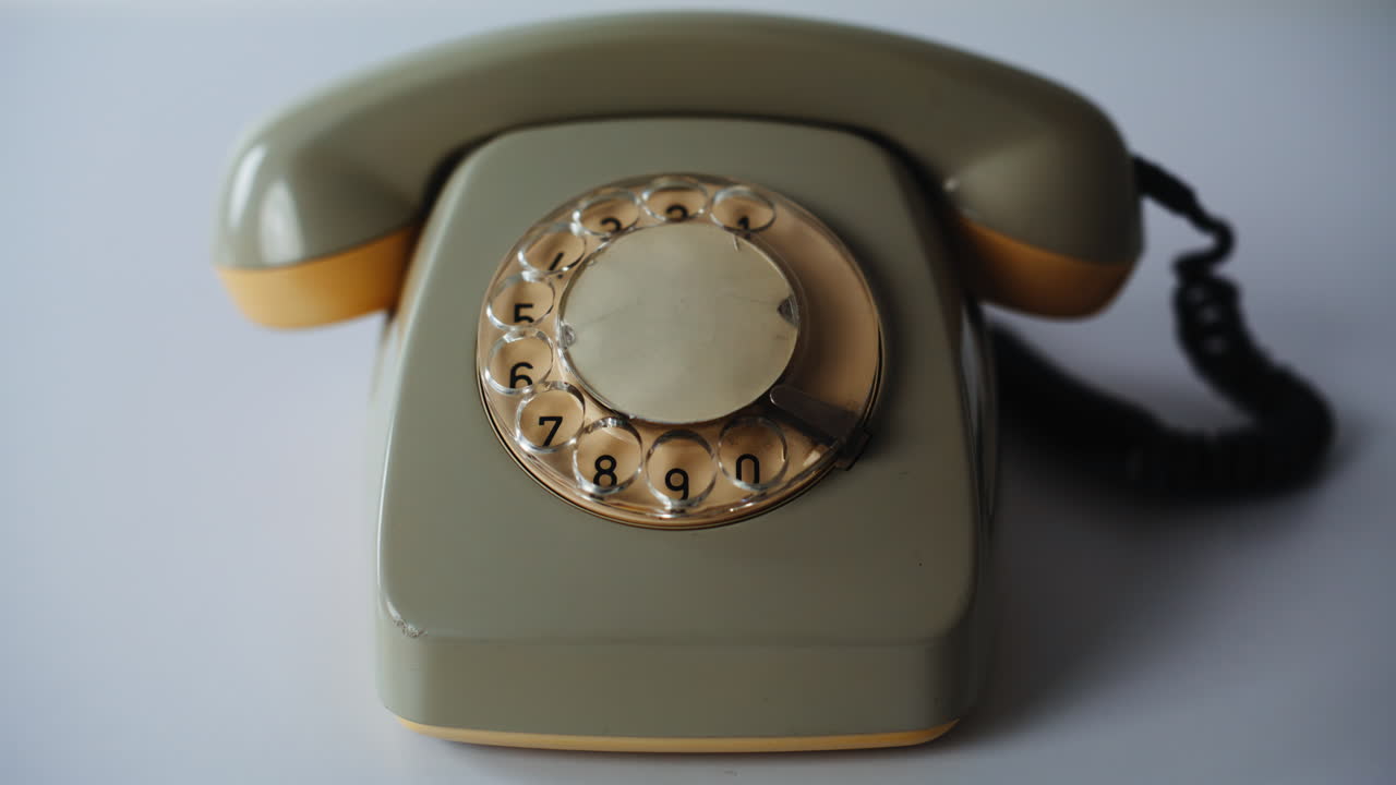 Old cellular telephone desk closeup. Retro rotary cell phone standing on white