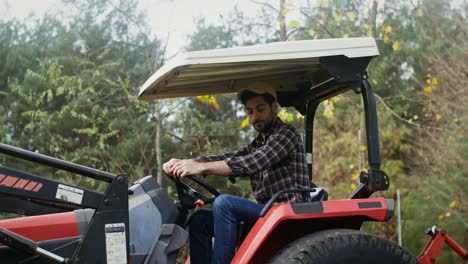 agricultor trabajando en un tractor en un bosque