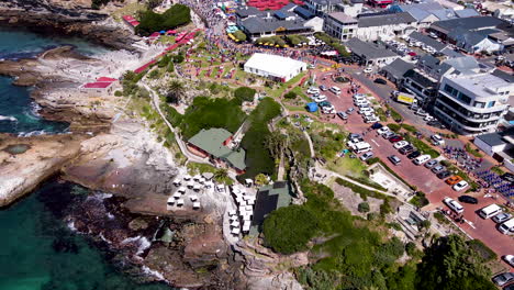 High-angle-tilt-up-over-Hermanus-coastline---hive-of-activity,-Whale-Festival