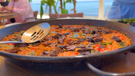 plato tradicional de paella español con verduras en un restaurante junto al mar, sabroso arroz cocido con verduras, marbella españa, 4k tiro