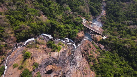 steep rock mountains of dudhsagar falls with railroad bridge, indian state of goa