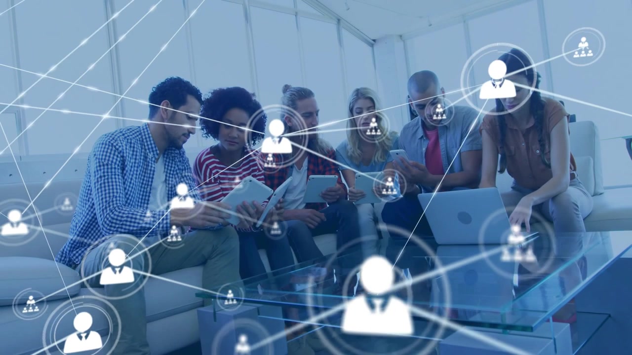 Team der læner sig ind, peger på en laptop og tablet, og driver et animeret netværksoverlay til forretningsbrug.