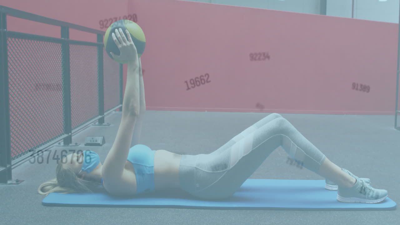 animación de números cambiando sobre una mujer con máscara facial haciendo ejercicio con una pelota en el gimnasio