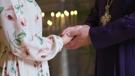 priest holding woman's hands