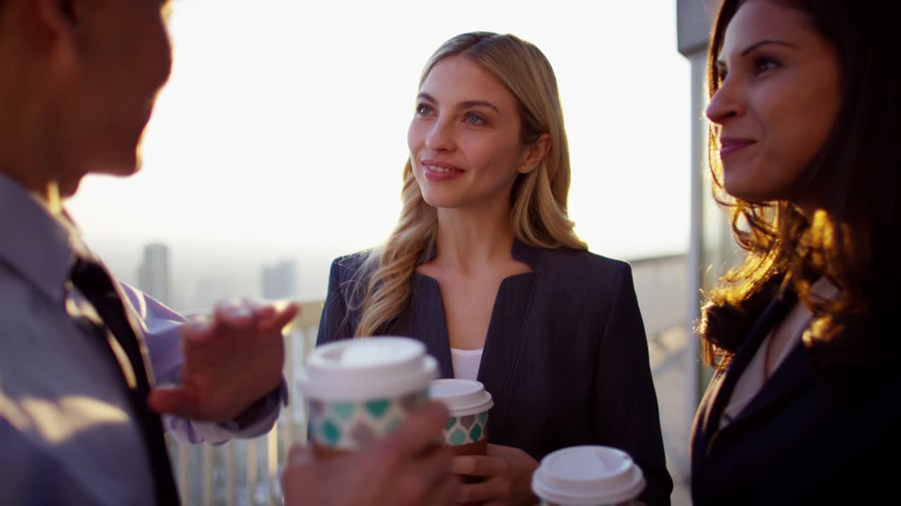 다민족 사업 관리자들이 지붕에서 커피를 즐기고 있습니다.