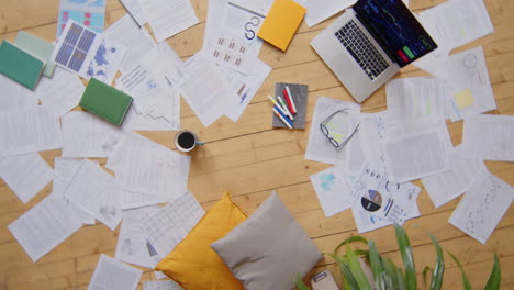 financial papers and laptop on floor