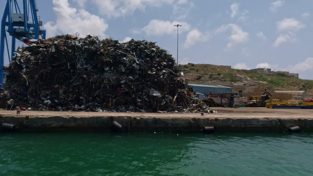 Passing the ship yard in Valletta, Malta with waste from containers piled on the pier