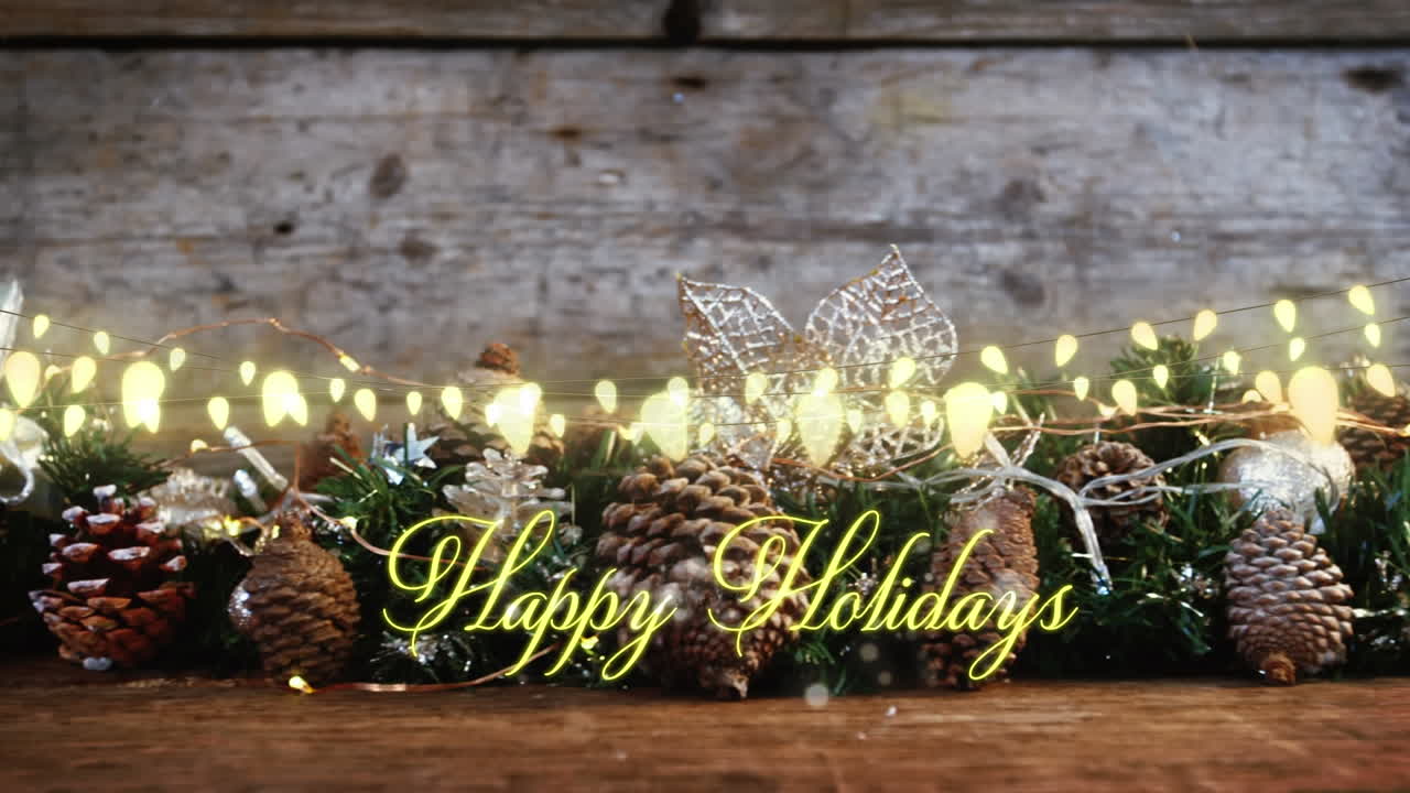 Animation of text, happy holidays, in yellow, over string lights and seasonal decorations