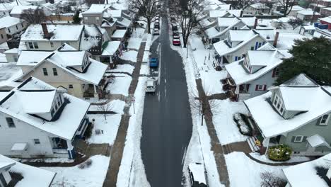 Person-clearing-sidewalk-full-of-snow-in-american-housing-area