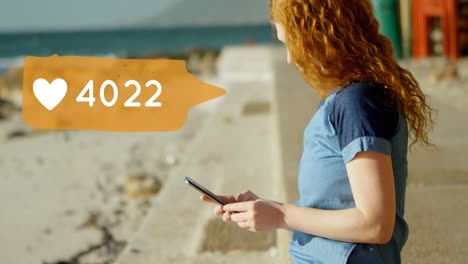 mujer sentada en la playa mientras envía mensajes de texto 4k