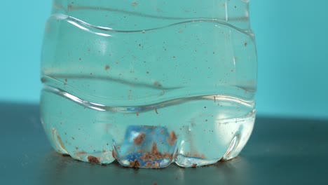 close-up of a dirty water bottle with sediment at the bottom