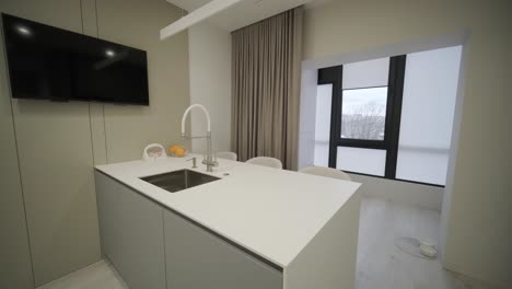 a luxurious kitchen with a large island, gold faucet and sputnik chandelier, stainless steel appliances, and white marble countertops.