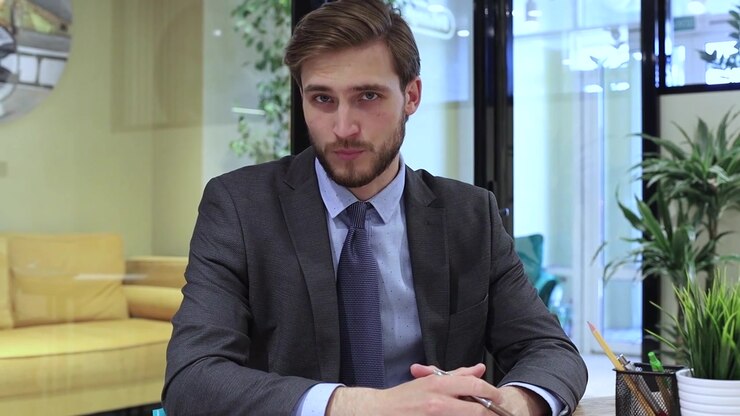 Young Businessman Speaking and Gesturing During a Video Call in Office