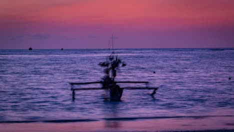 timelapse of sunset on beach with fishing boat and vibrant colours