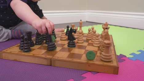 curious baby boy playing a game of chess