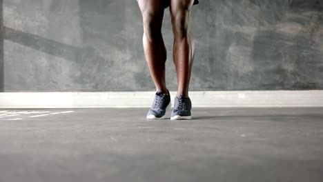 jumping rope, african american man exercising in gym focus on fitness and leg strength, copy space