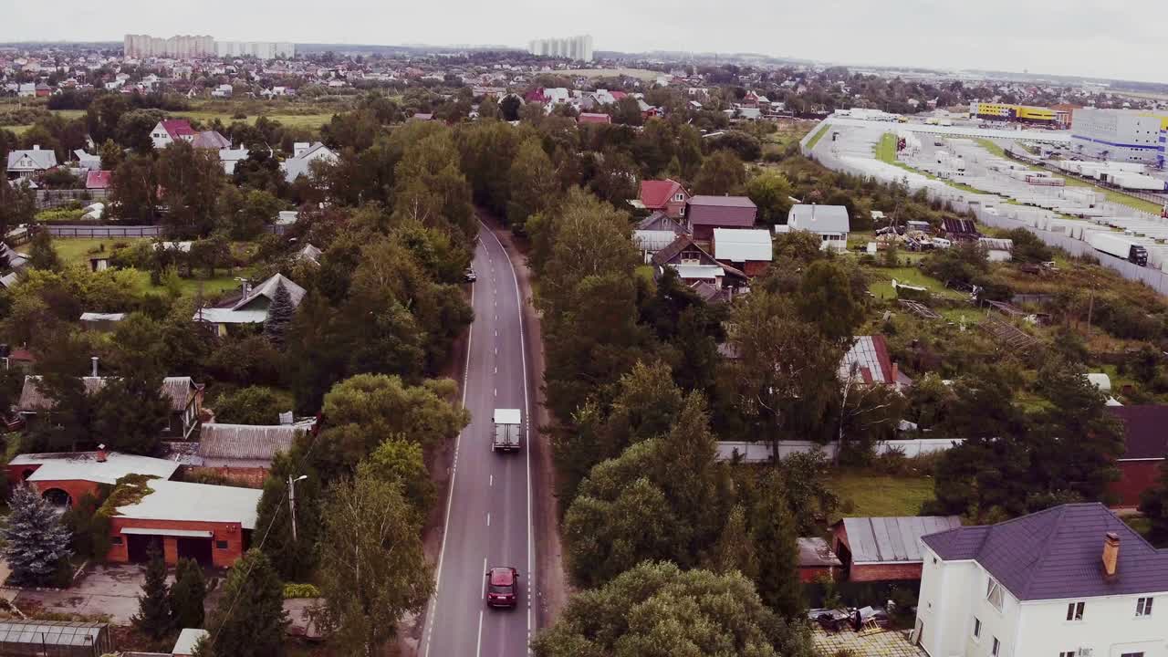disparo aéreo de camiones que conducen por la carretera rodeados de bosque