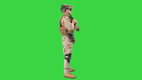 soldier with machine gun standing on a green screen, chroma key